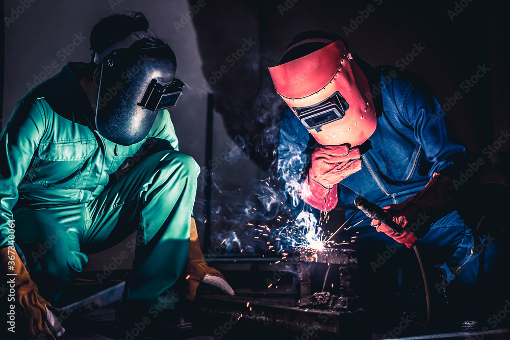 Metal welding steel works using electric arc welding machine to weld steel at factory. Metalwork man