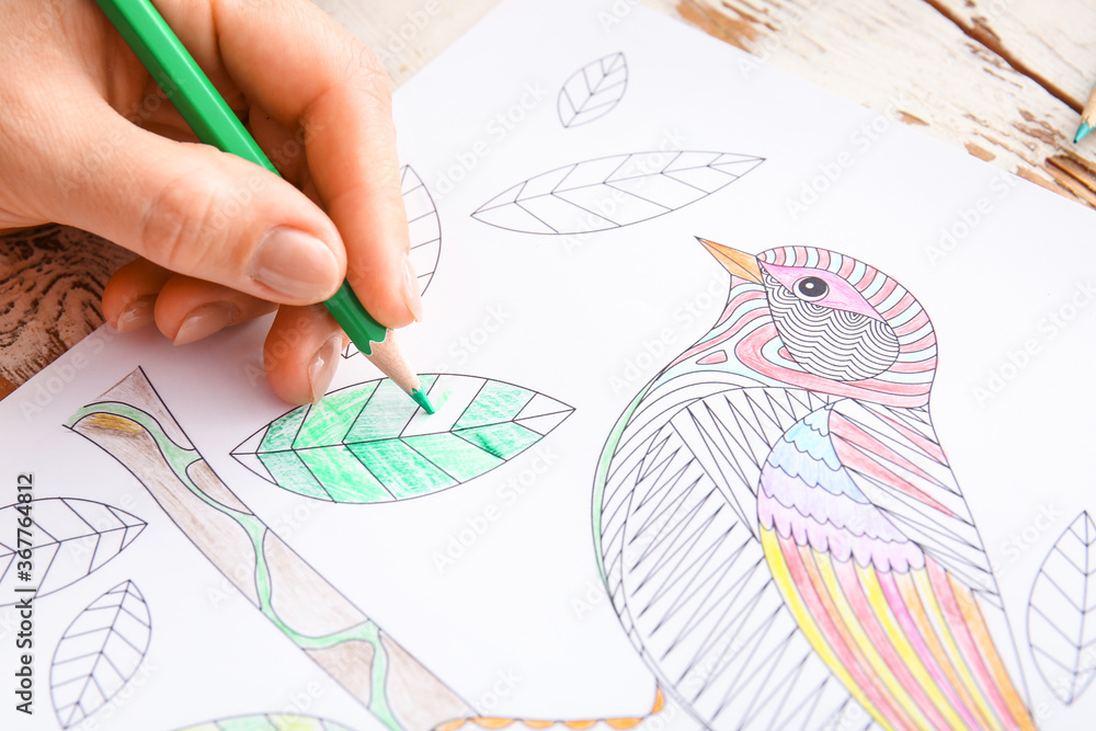 Woman coloring picture at table, closeup