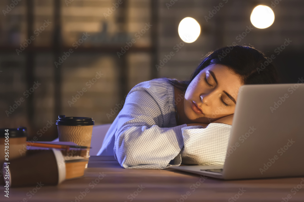 Student sleeping at table late in evening