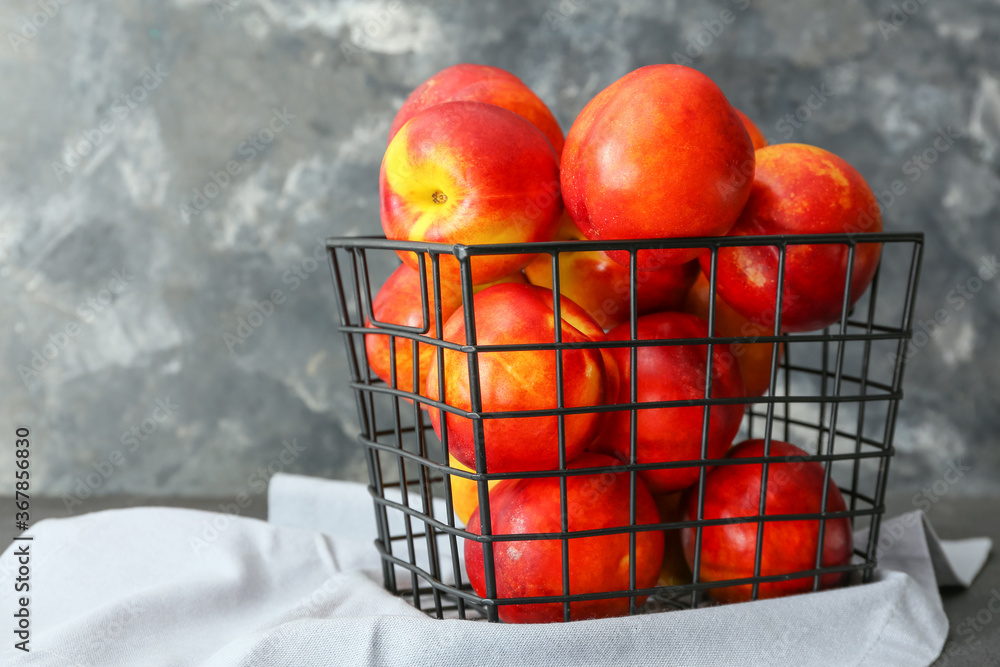 Sweet ripe nectarines in basket on table