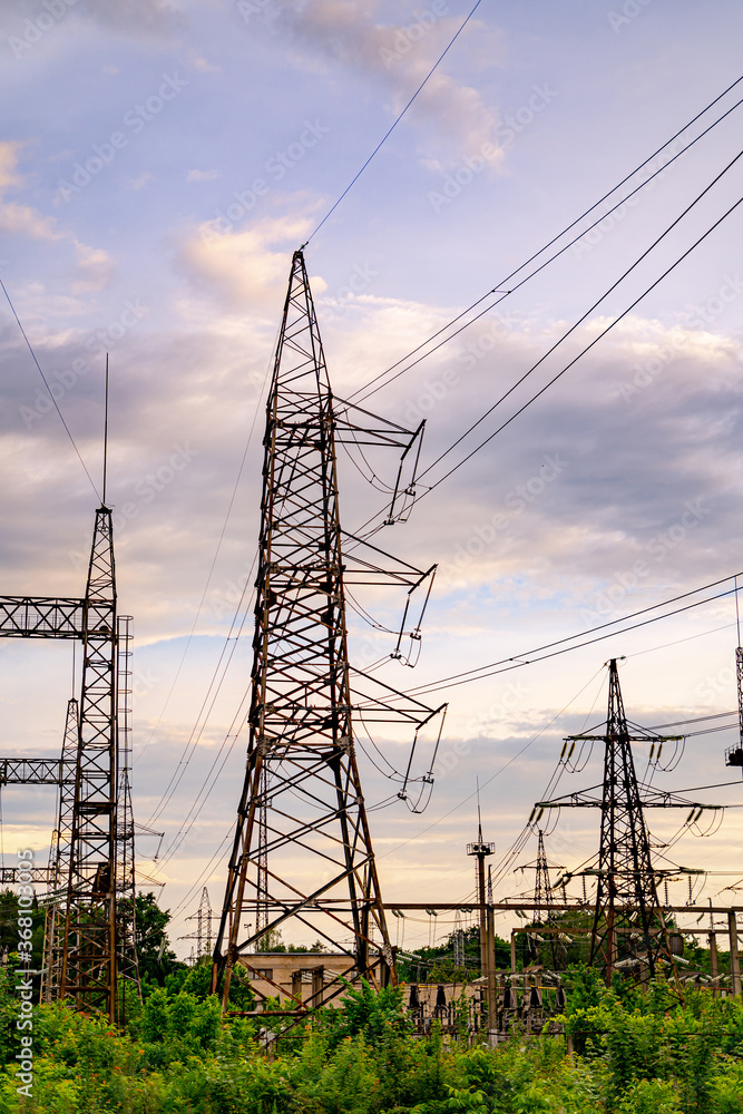 Electricity pylons and high-voltage power lines on the green grass. Power plant. Electrical power gr