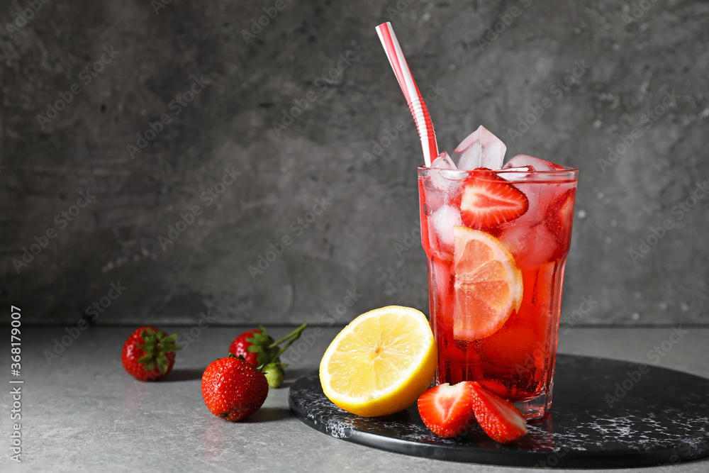 Glass of fresh strawberry lemonade on table