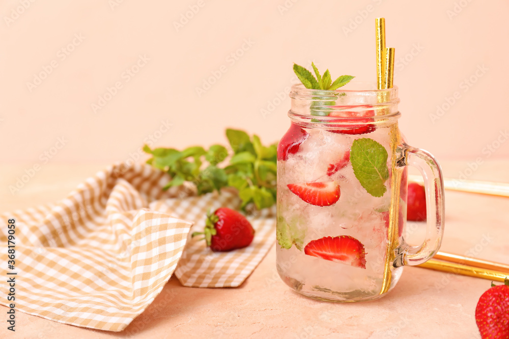 Mason jar of fresh strawberry lemonade on color background