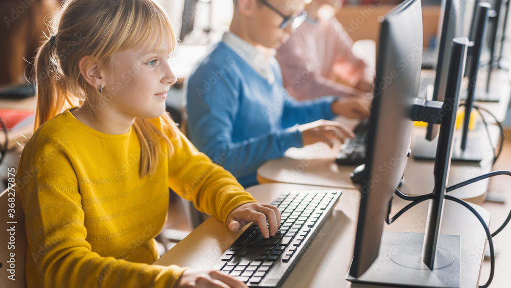 Elementary School Computer Science Classroom: Cute Little Girl Uses Personal Computer, Learning Prog