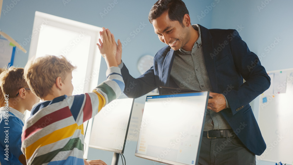 Elementary School Computer Science Classroom: Teacher Uses Tablet Computer, Explains Lesson to Diver