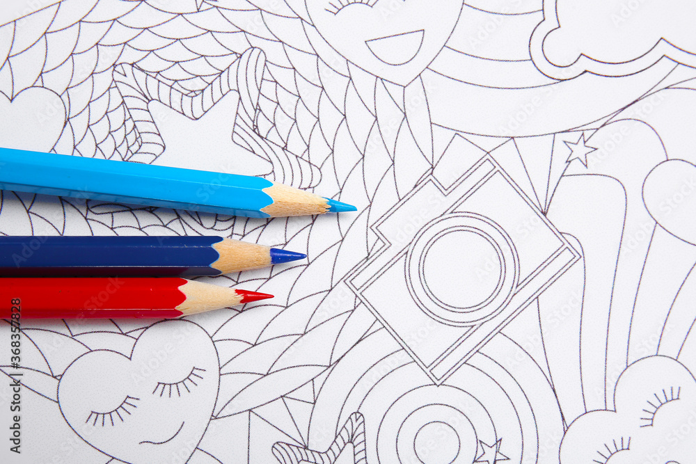 Coloring picture and pencils on table