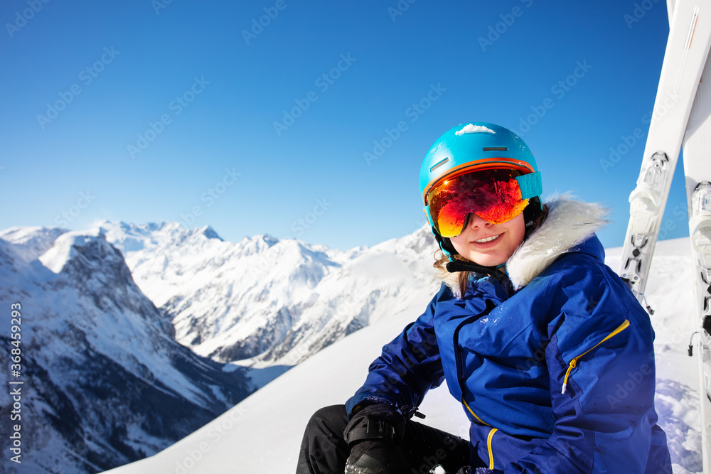 一个戴着滑雪帽、戴着口罩的少女在山顶微笑的快乐画像