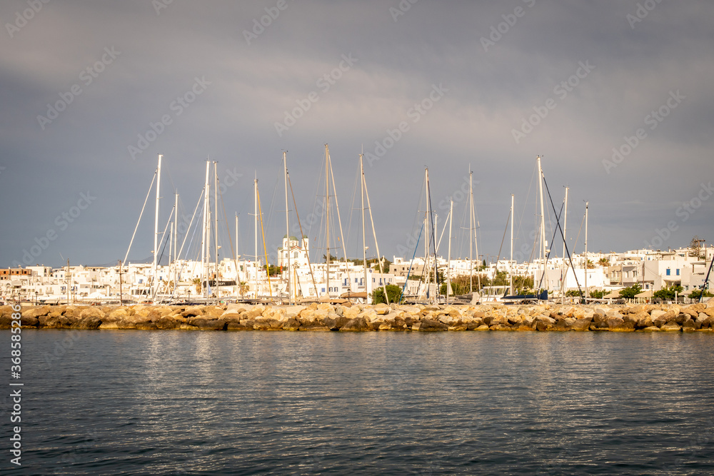 Row of sailing boats docked in marina in Naoussa coastal village (Paros Island) landscape view durin