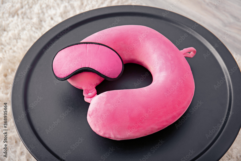 Travel pillow and sleep mask on table in room