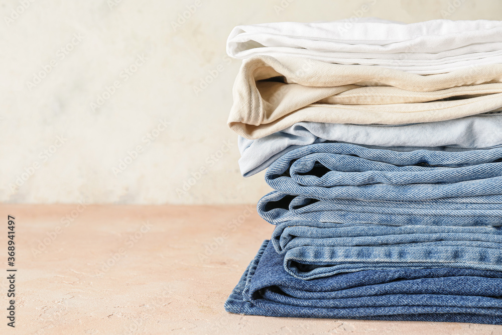 Stack of jeans pants on table