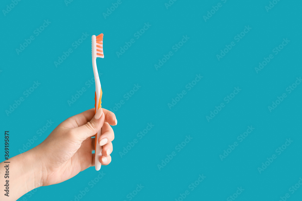 Hand with tooth brush on color background