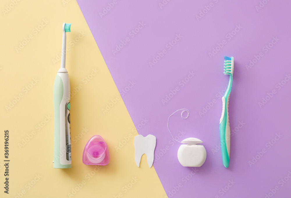 Tooth brushes and floss on color background