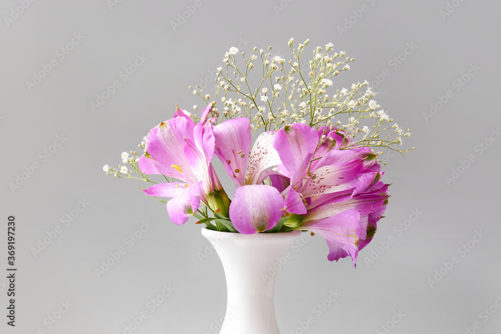 Beautiful vase with flowers on grey background