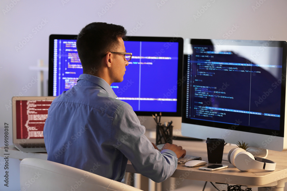 Male programmer working in office at night