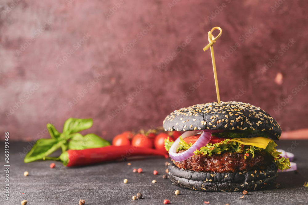 Tasty burger with black bun on table