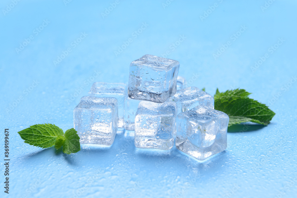 Ice cubes and mint on color background