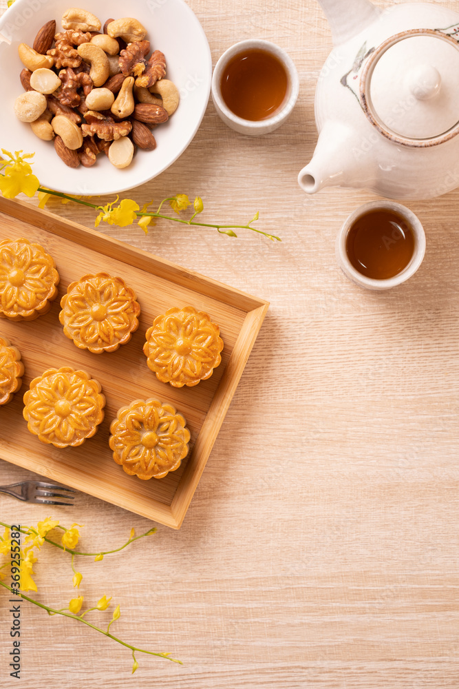 Mid-Autumn Festival holiday concept design of moon cake, mooncakes, tea set on bright wooden table w