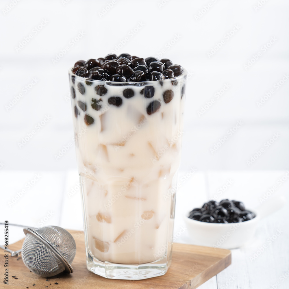 Bubble milk tea with tapioca pearl topping, famous Taiwanese drink on white wooden table background 