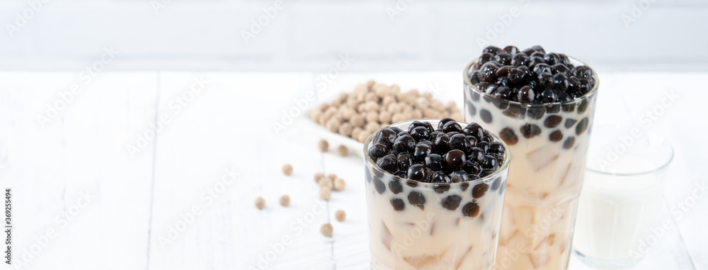 Bubble milk tea with tapioca pearl topping, famous Taiwanese drink on white wooden table background 