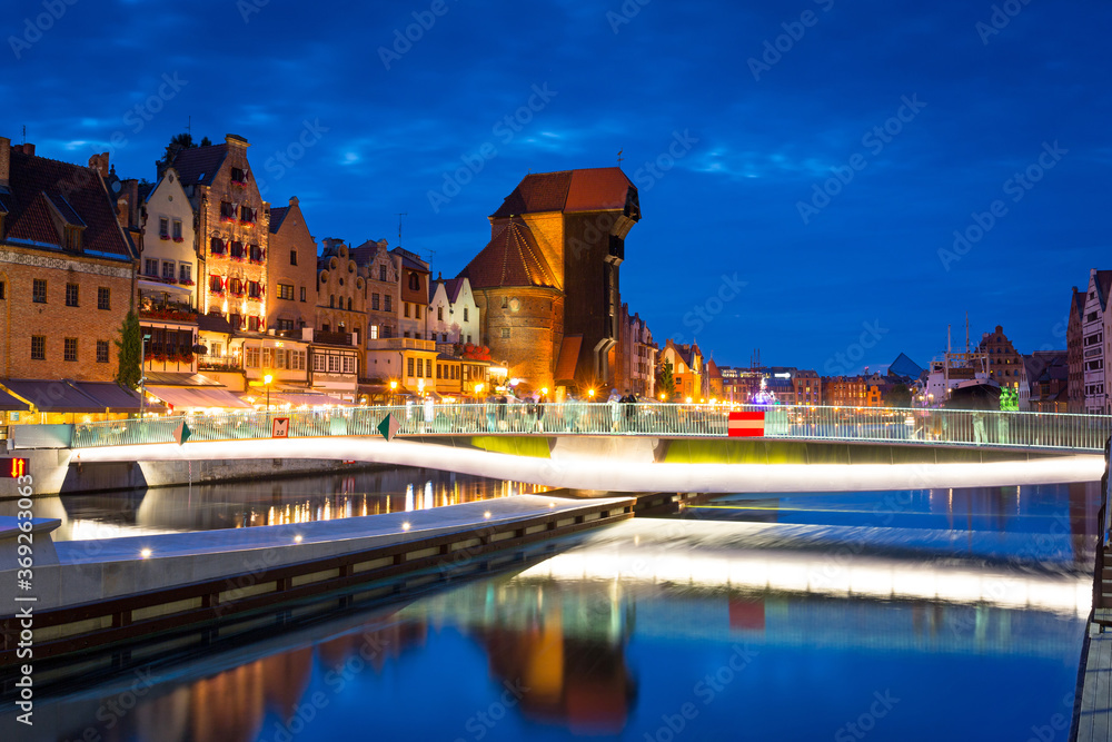 Amazing architecture of Gdansk old town at night with a new footbridge over the Motlawa River. Polan