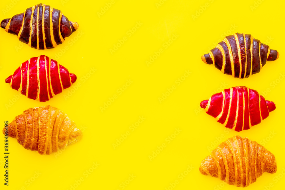 Frame of croissants - fresh bakery on yellow background. Top view