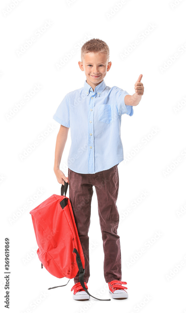 Cute little schoolboy showing thumb-up on white background