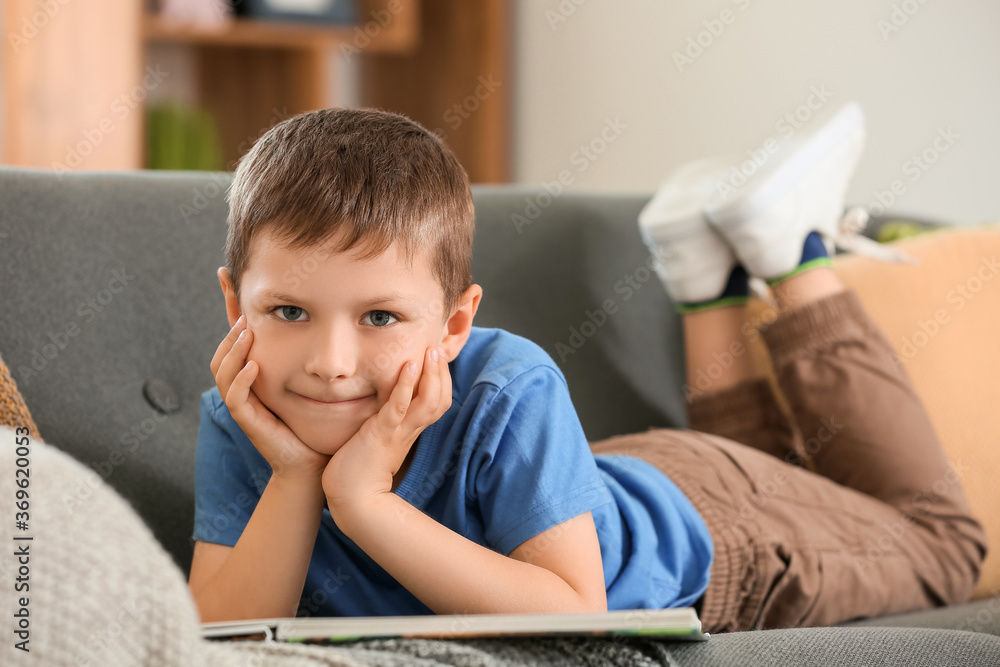 Cute little boy reading book at home