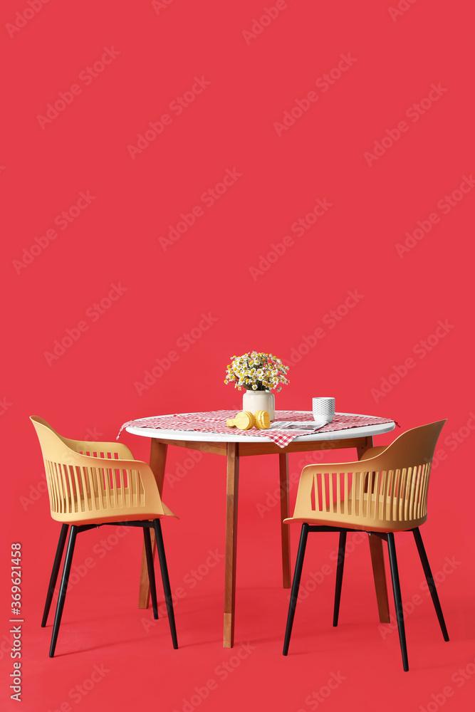 Dining table with chairs on color background