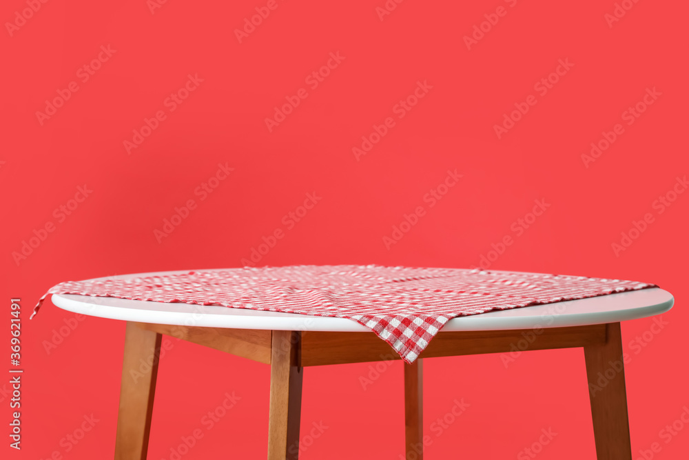 Dining table with tablecloth on color background