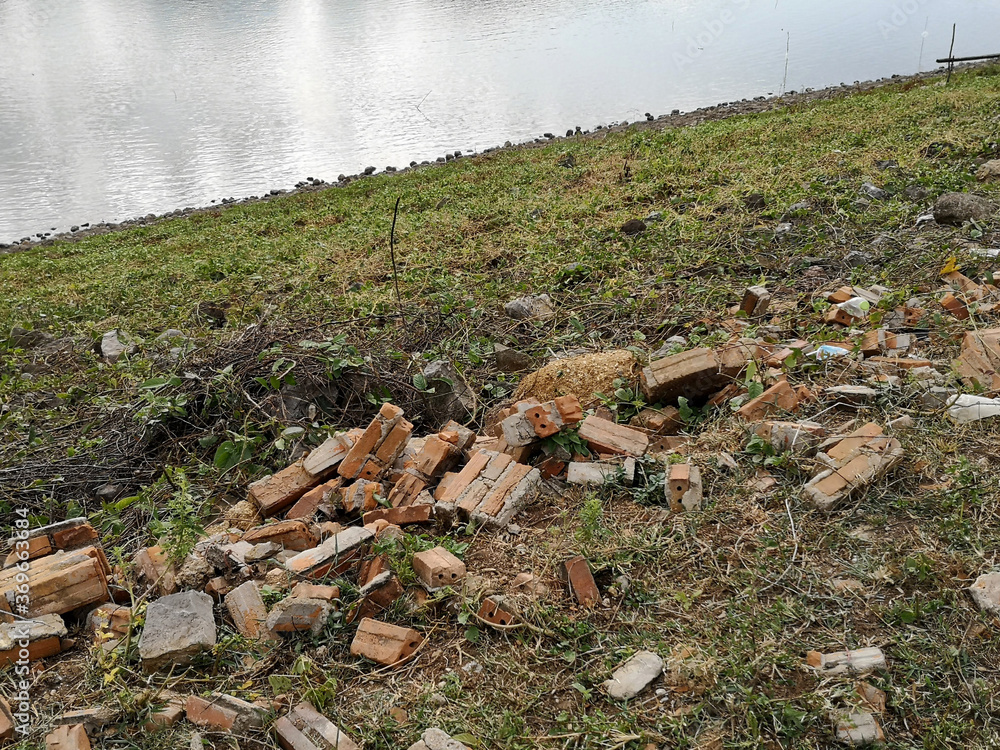 A pile of bricks on the outdoor grass near the pool