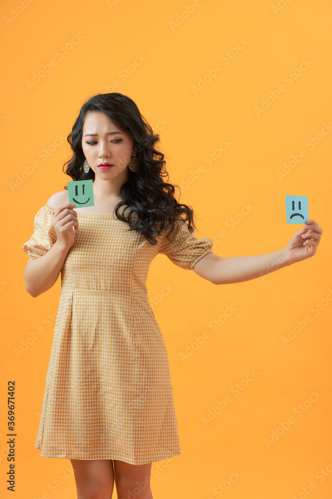 Close-up portrait of attractive sad girl  holding in hands two draw notes negative bad gloomy choice