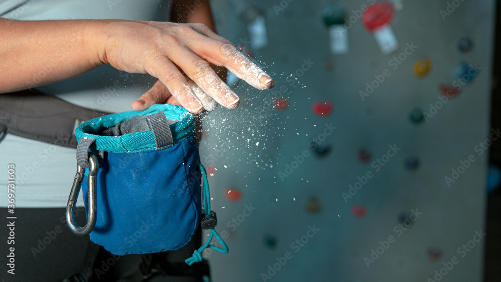 CLOSE UP: Unrecognizable female climber flicks excess magnesium off fingertips