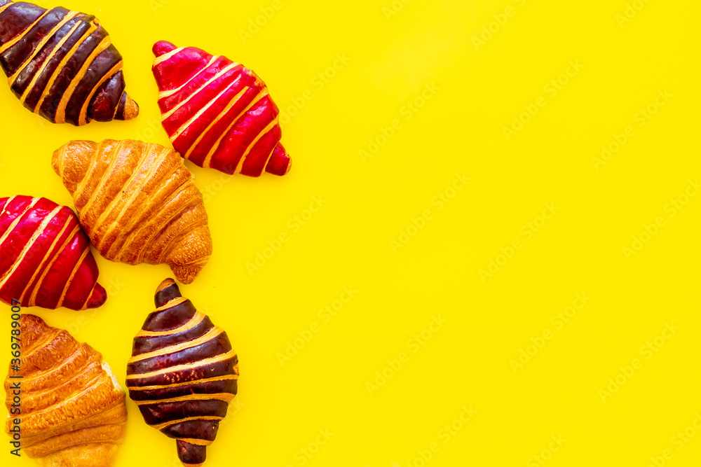 Set of croissants - chocolate, berry, classic - on yellow background top view