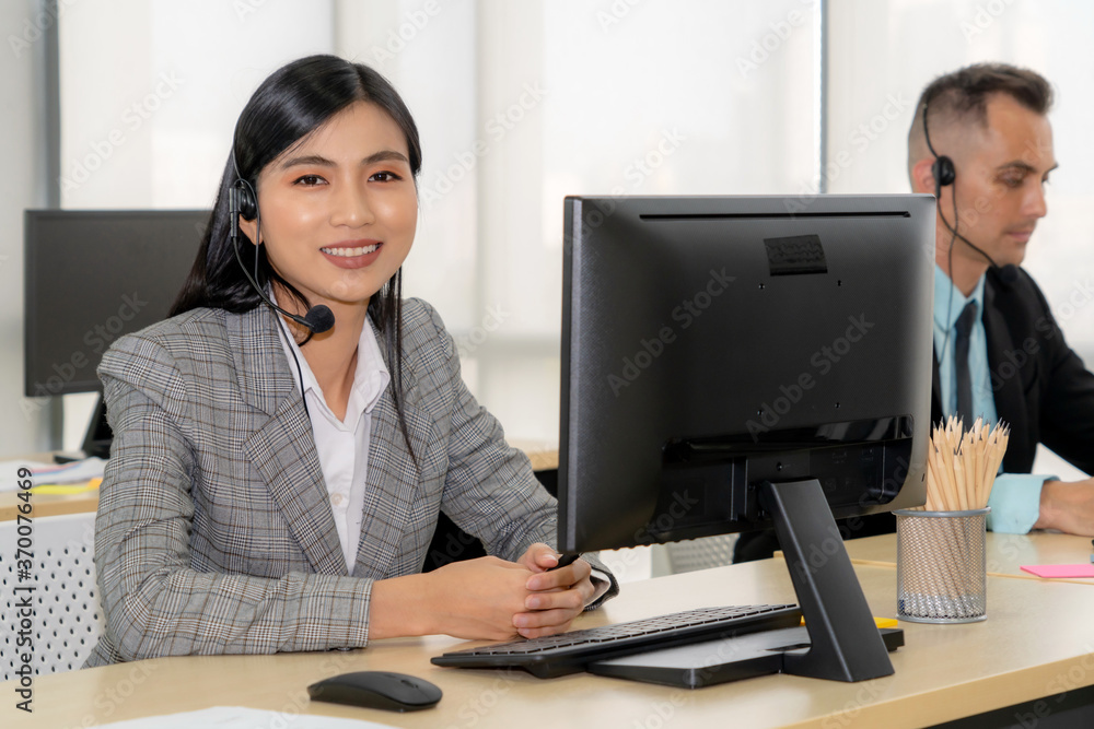 Business people wearing headset working in office to support remote customer or colleague. Call cent