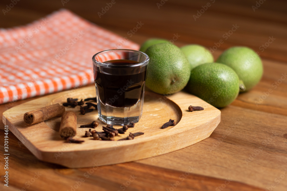 homemade nocino with green walnuts, cinnamon sticks and cloves.