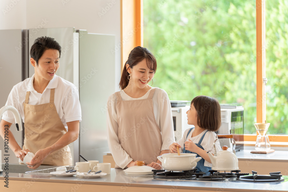 キッチンで料理を作る女の子と両親