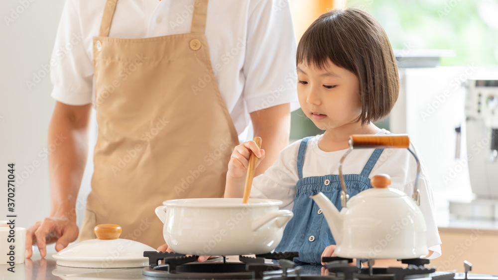 キッチンで料理を作る女の子と両親