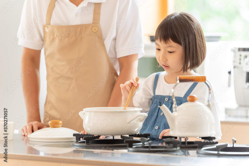 キッチンで料理を作る女の子と両親