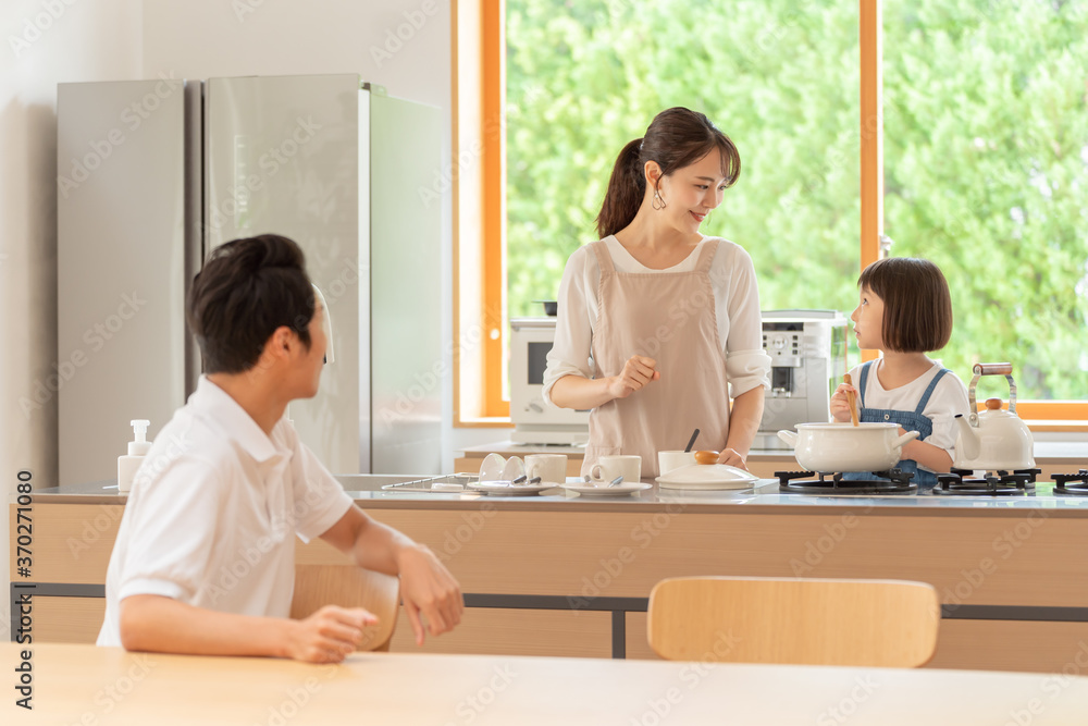 キッチンで料理を作る女の子と両親