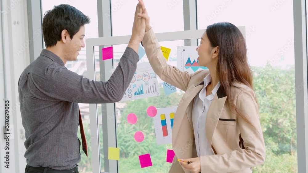 Business people work on project planning board in office and having conversation with coworker frien