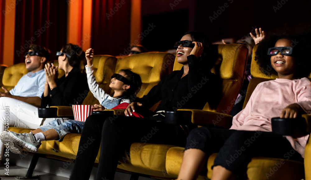 Group of people watch movie with 3D glasses in cinema theater with interest looking at the screen, e