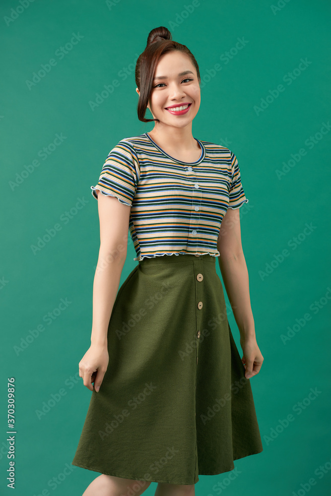 Portrait of happy smiling young beautiful woman, isolated over green background