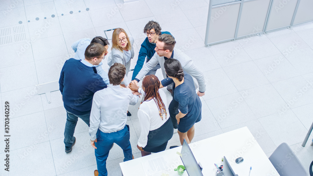 Eight Successful Office Workers doing Team Building Exercise Stacking Hands Together in the Unifying