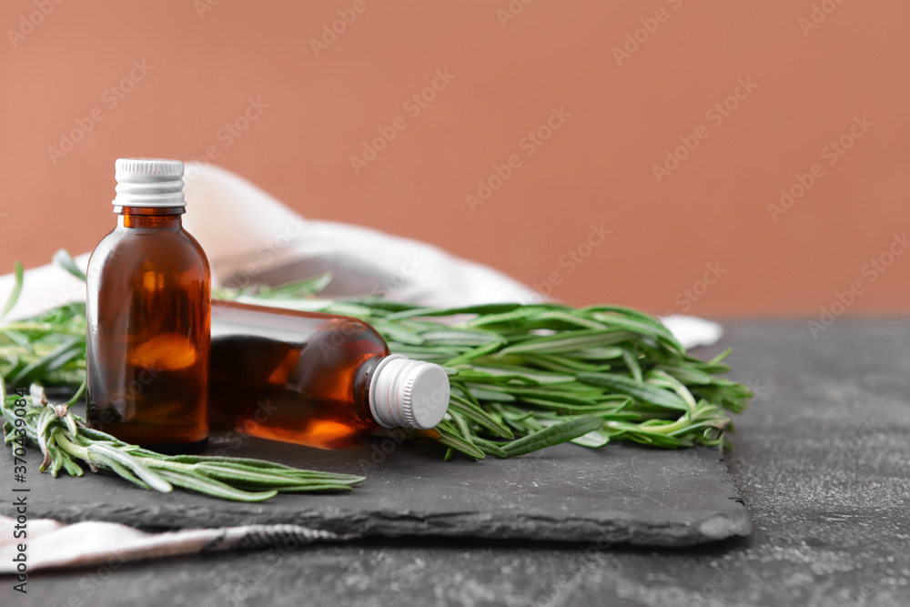 Bottles of rosemary essential oil on table