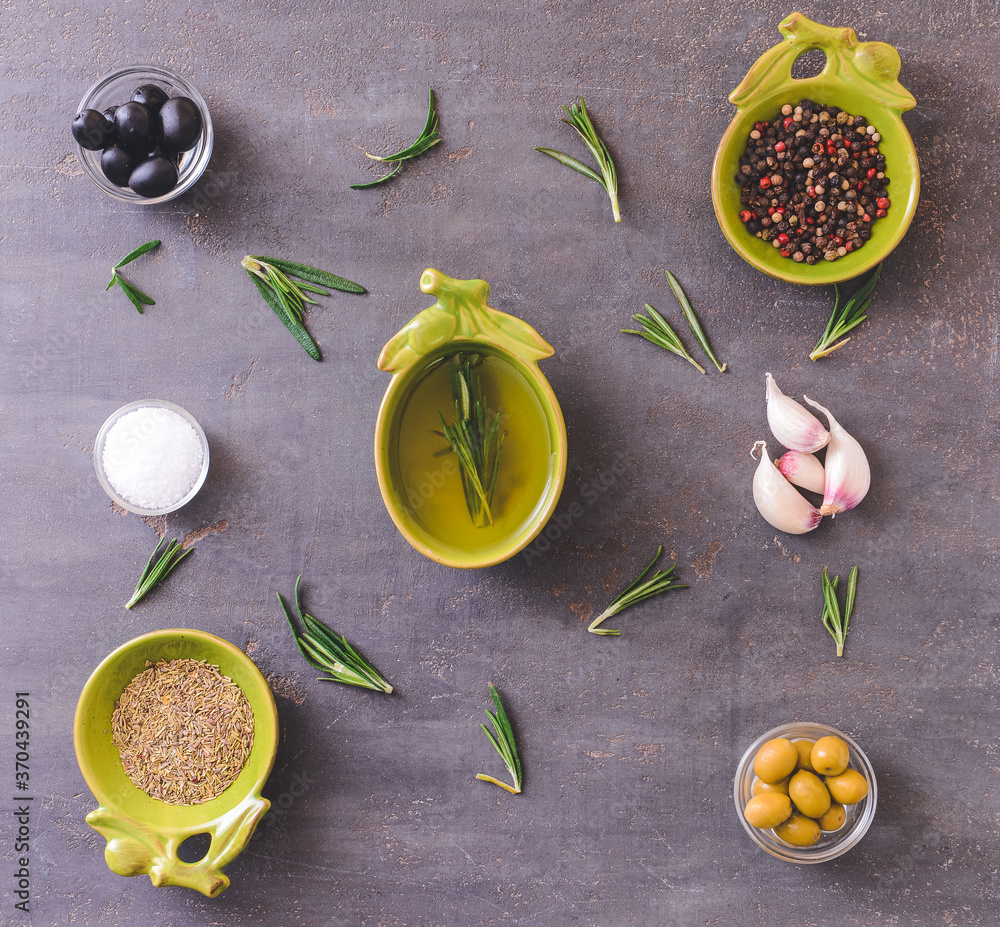 Rosemary oil and spices on dark background