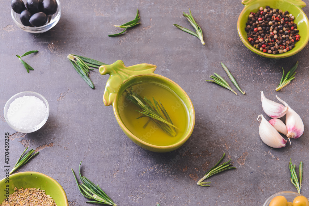 Rosemary oil and spices on dark background