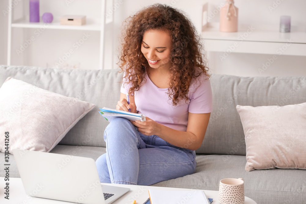 Young woman using laptop for online learning at home