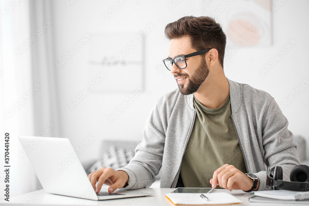 Young man using laptop for online learning at home