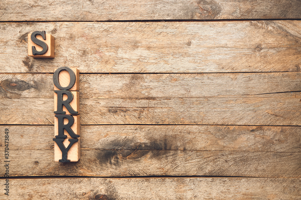 Cubes with word SORRY on wooden background