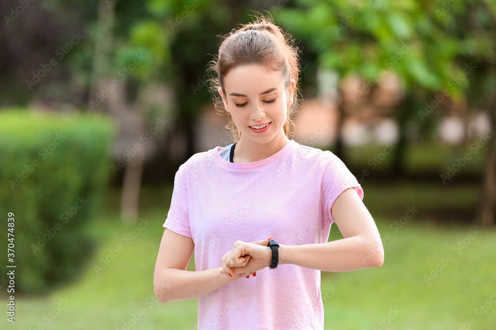 户外带健身追踪器的运动型年轻女性